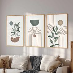 three paintings hang on the wall above a couch in a living room with white walls