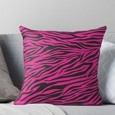 a pink and black zebra print pillow on a couch