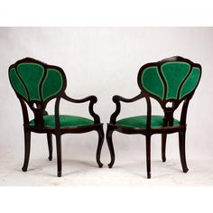 a pair of chairs with green upholstered back and armrests on each side