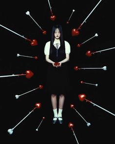 a woman standing in front of an array of red and white arrows with hearts on them