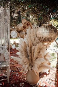 an image of a vase filled with feathers on top of a rug next to a birdcage