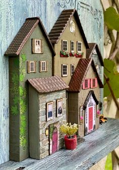 a couple of houses sitting on top of a wooden shelf