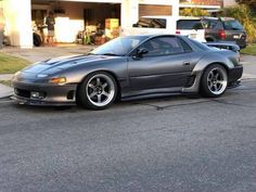 a gray sports car parked in front of a garage