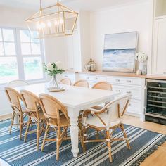 a dining room table with chairs and a rug in front of it