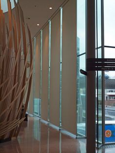 a large wooden sculpture sitting in the middle of a room next to a window with glass doors