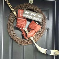 a wreath with hockey gloves and sticks hanging from it's front door that says welcome to hockey season