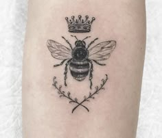 a bee with a crown on it's head is shown in this tattoo design