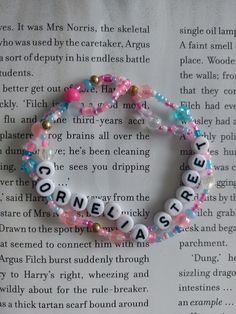 a bracelet with words written on it sitting on top of an open page of a book