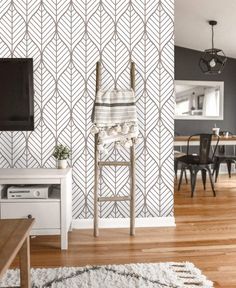 a living room with a tv, table and chair next to a wallpaper design