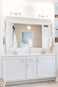 a white bathroom with two sinks and mirrors