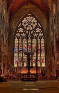 the inside of a church with stained glass windows and pews in front of it