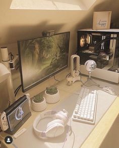 a computer desk with two monitors and headphones on it