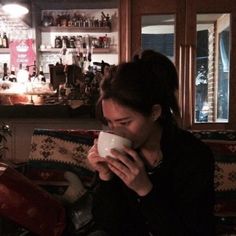 a woman sitting on a couch holding a cup