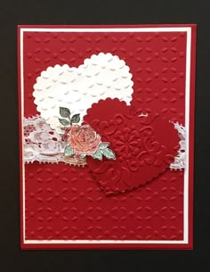 a close up of a red card with white doily on it and a flower