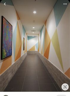 an empty hallway with paintings on the walls