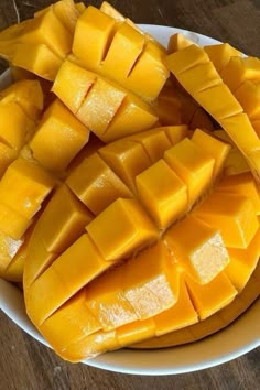 a white plate topped with sliced mangoes on top of a wooden table