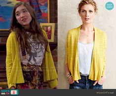 the young woman is wearing a yellow cardigan sweater