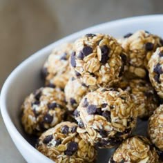 a bowl filled with oatmeal chocolate chip energy bites on top of a table