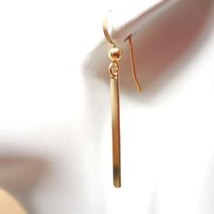 These beautiful golden earrings are a must for your jewelry collection. Minimalist sleek 14k gold filled bar dangles that are a great finishing touch for any outfit. Slender, long, but not too long, minimalist and easy to wear for work or play.  The long slender bar hangs from small gold filled ear wires with a total length of approximately 1.5" from the top curve of the ear wire to the bottom of the gold bar. Please feel free to ask me any questions you may have about this item while deciding on your purchase and thank you for shopping with McKean Creations. Marcia Gold Bar Earrings, Golden Earrings, Bar Earrings, Gold Bar, Ear Wire, The Ear, Ear Wires, Jewelry Earrings Dangle, Gold Filled