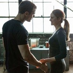 a man and woman standing next to each other in front of a stove top oven