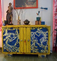 a yellow cabinet with blue and white designs on it