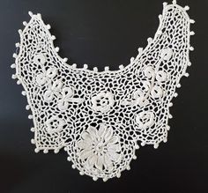 a white crocheted collar with flowers on it