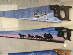 three skis are hanging up on the wall with deer and sleigh paintings