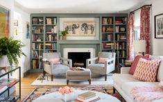 a living room filled with furniture and bookshelves next to a fire place under a painting