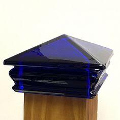 a blue glass object sitting on top of a wooden stand