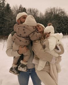 a man and woman holding two children in the snow