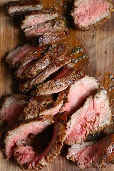 sliced steak on a cutting board with seasoning