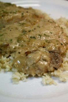 a white plate topped with rice and meat covered in gravy on top of it