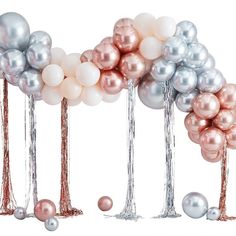 several balloons are lined up in the shape of palm trees with pink and silver balls