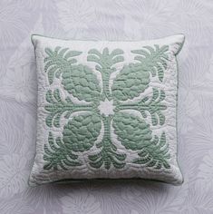 a green and white pillow sitting on top of a bed