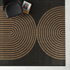 a black chair sitting on top of a rug next to a table with a book