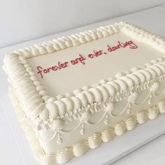 a white cake with frosting that reads forever after, and is decorated with seashells