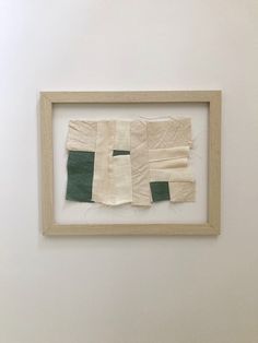 a piece of cloth is hanging on the wall next to a wooden frame that has been stitched together