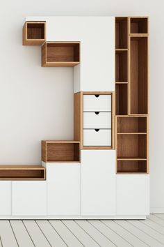 an empty room with some shelves and drawers on the wall next to a white floor