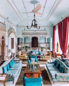 a living room filled with lots of blue couches