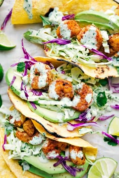 shrimp tacos with avocado, cabbage and cilantro slaw are served on corn tortillas