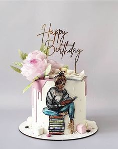 a birthday cake decorated with an image of a person sitting on a stack of books