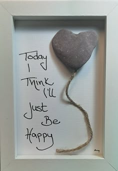 a heart shaped rock in a frame with the words today i think i'll just be happy