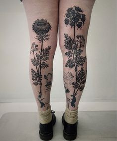 a woman's legs with tattoos and flowers on them