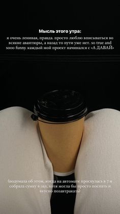 a coffee cup sitting on top of a person's lap in front of a black background