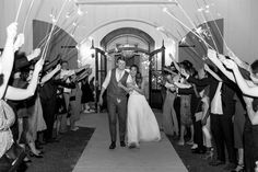 a bride and groom walk down the aisle with sparklers in their hands as they exit