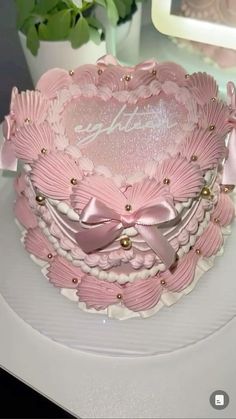 a pink heart shaped cake on top of a white plate