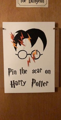 a harry potter poster hanging on the wall next to a sign that says pin the scar on harry potter