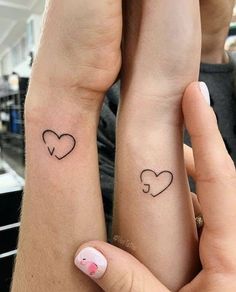 two people with matching tattoos on their arms