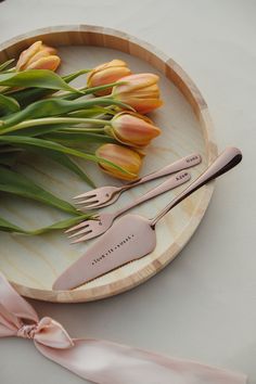 two forks and one knife on a plate with tulips