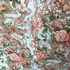 a blue floral wallpaper with pink flowers and vines on it's side,